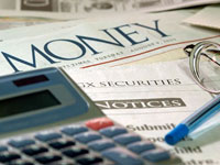 Foto: particolare di calcolatrice, penna e occhiali sulla prima pagina del 'Money'